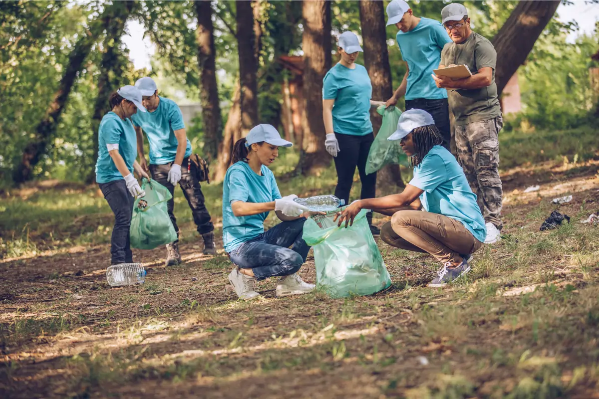 Idée de séminaires entreprises : Nettoies ta nature. Un groupe de personnes ramassant les déchets dans la nature