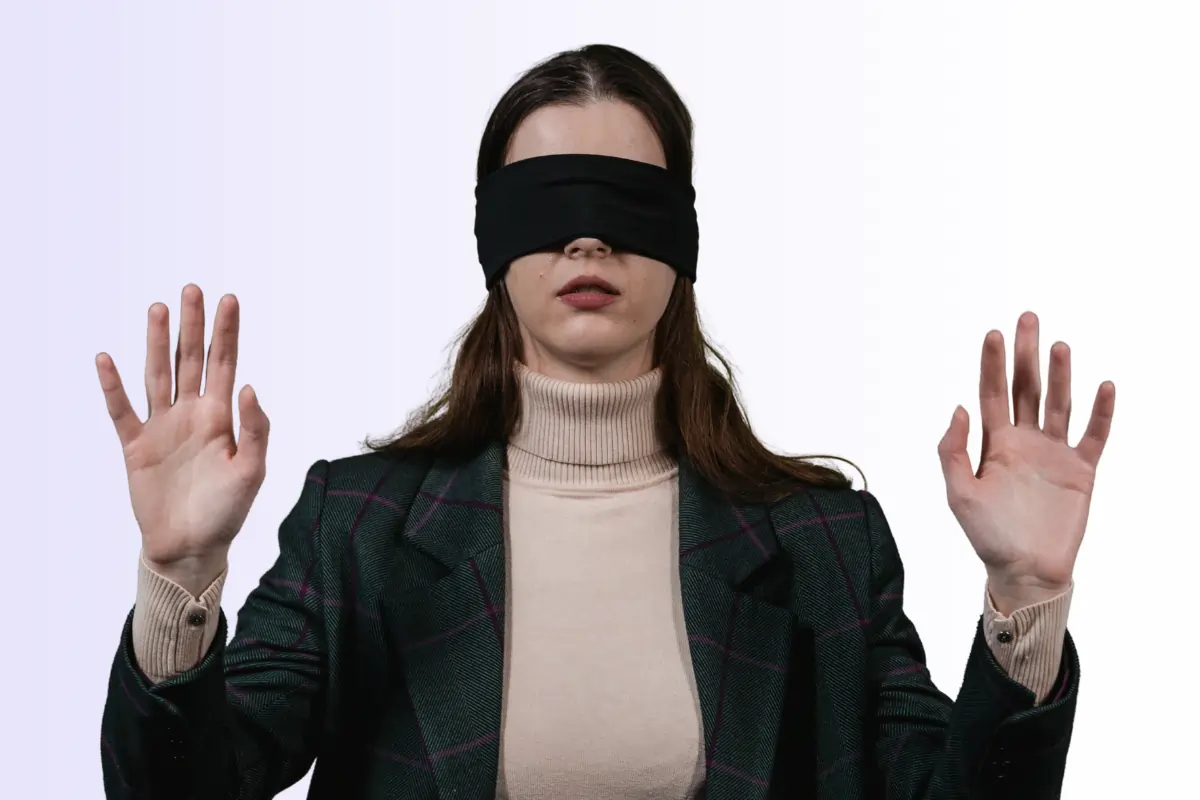 une femme avec les yeux bandés pour illustrer l'idée d'angle mort, de choses qu'on ne voit pas 