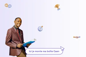 Un homme professionnel et souriant avec un cahier ouvert entre les mains. Il apparait sous lui une phrase illustrant le sujet de l'article : "Ici je monte ma boîte Caen"