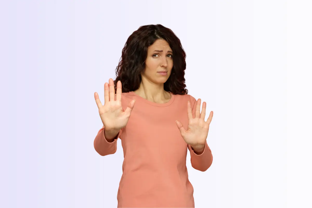 Une femme retissante montrant les paumes de ses mains face au spectateur en preuve de recul suite à son refus de reclassement et outplacement 